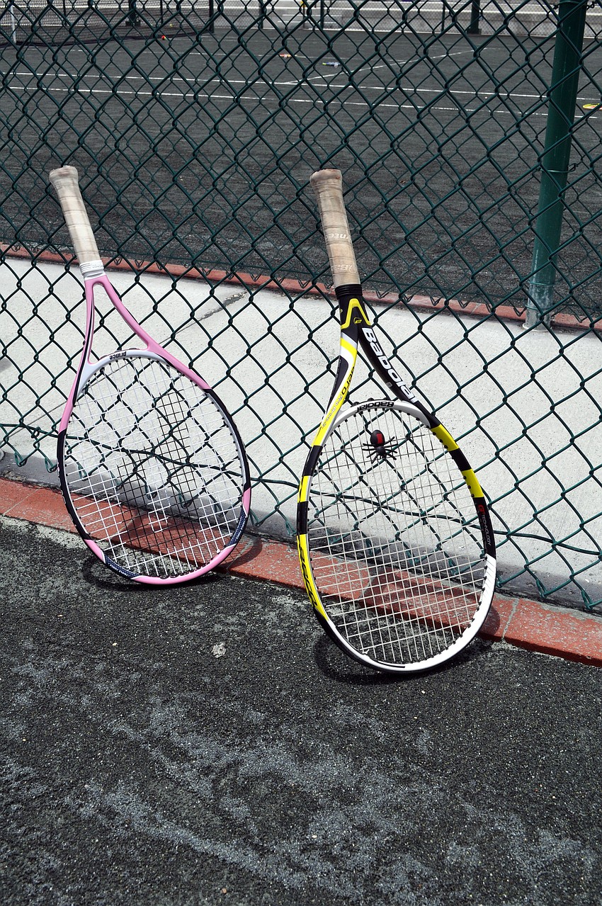 Tennis campers put their rackets up against the fence on Court 2 at the Longboat Key Club Tennis Gardens, Monday, July 23.