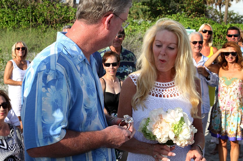Admiral Steve Branham presents Susan with her â€œringâ€, a fake diamond cocktail napkin ring, Saturday, July 28, during the wedding ceremony.