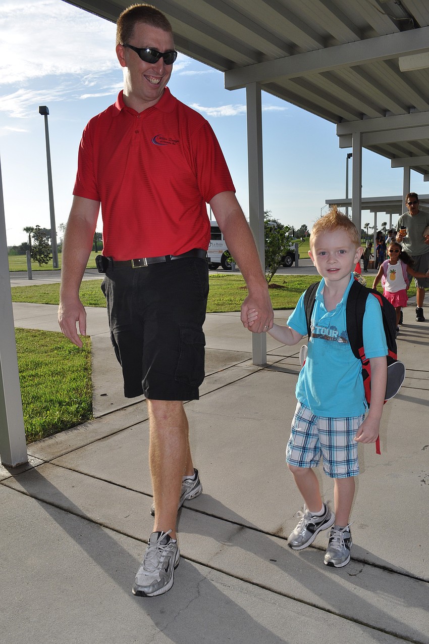First-grade student Evan Brown showed no signs of nervousness as he walked in with his dad, Kevin, right.