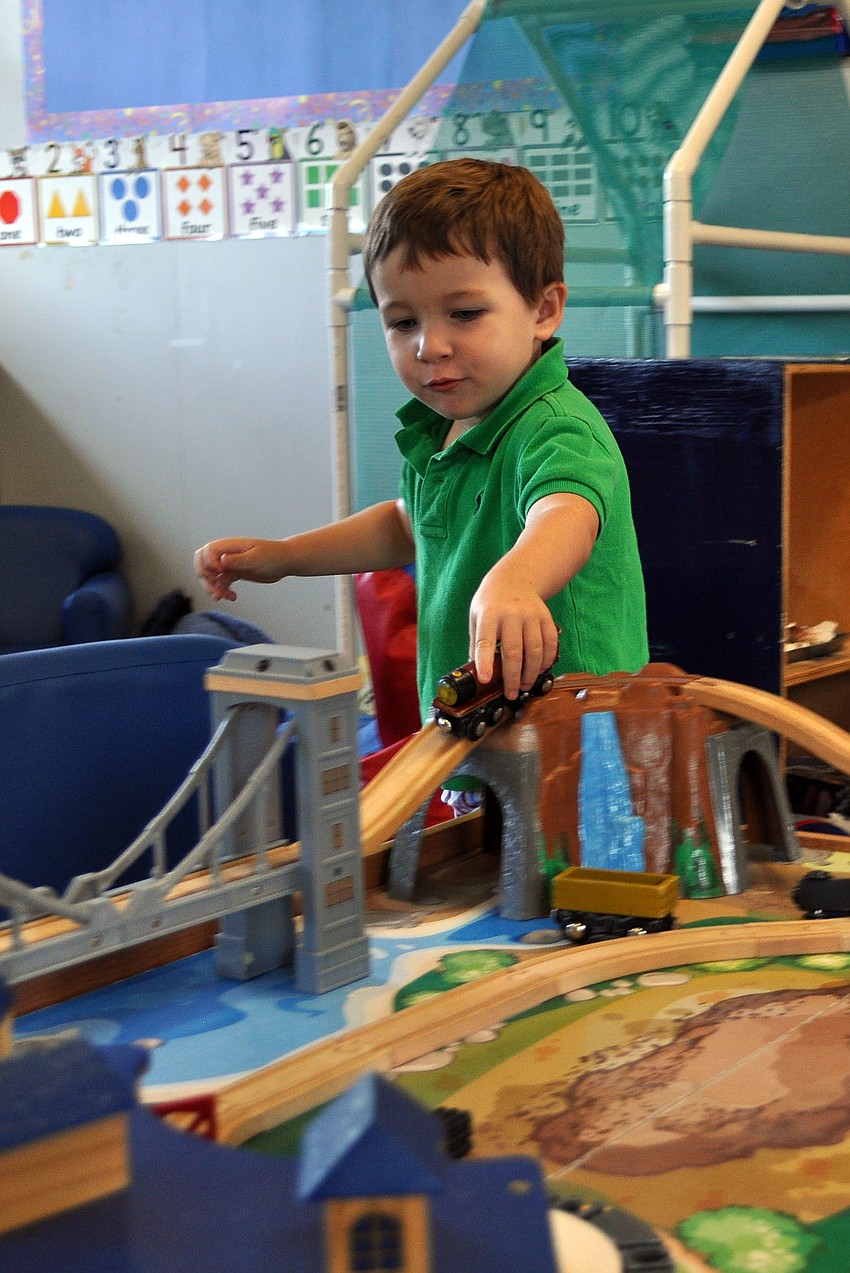 Cooper NaDell plays with the train set in the Dolphin classroom, Monday, Aug. 20.