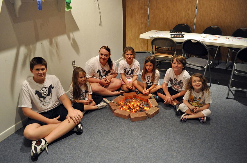Campers sit around a mock fire.