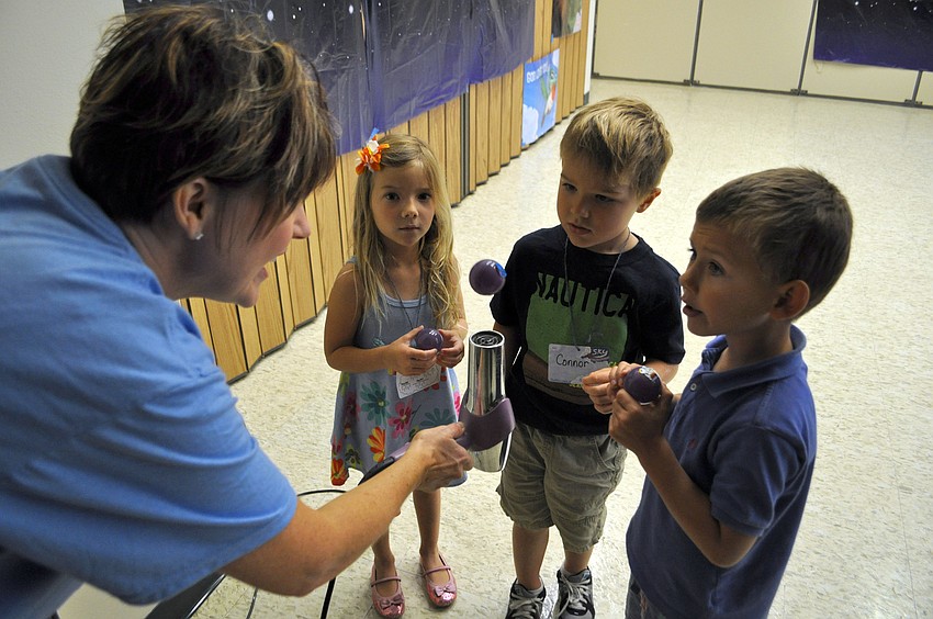 Students watch as a ball floats above a hairdryer.