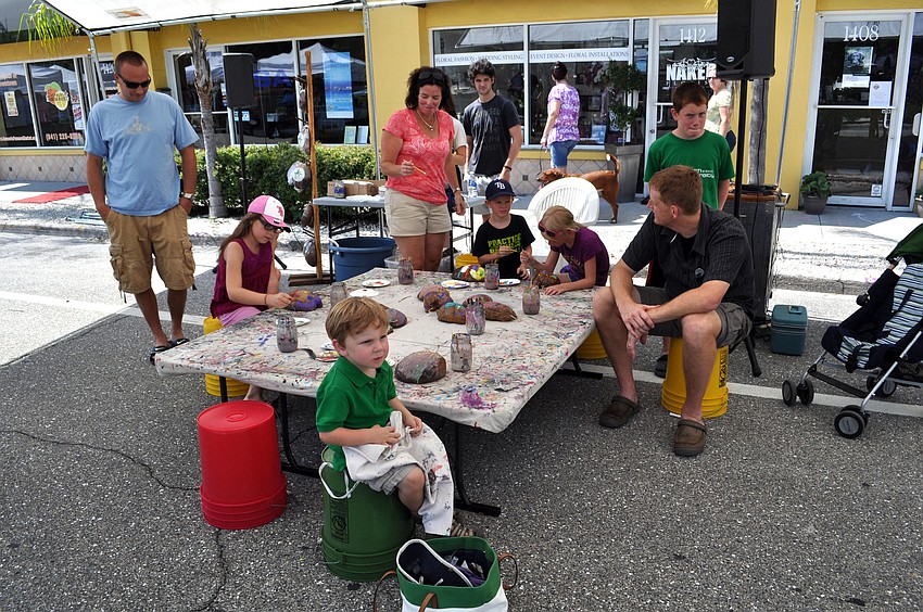 Kids watch a puppet performance as they work on crafts.