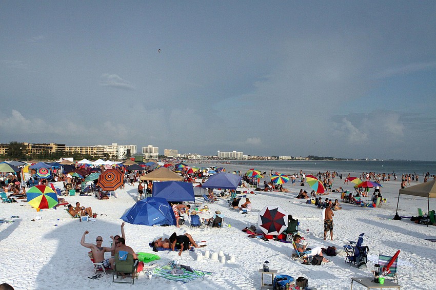 Thousands of people set up umbrellas, tents and chairs, Wednesday, July 4, on Siesta Key Public Beach.