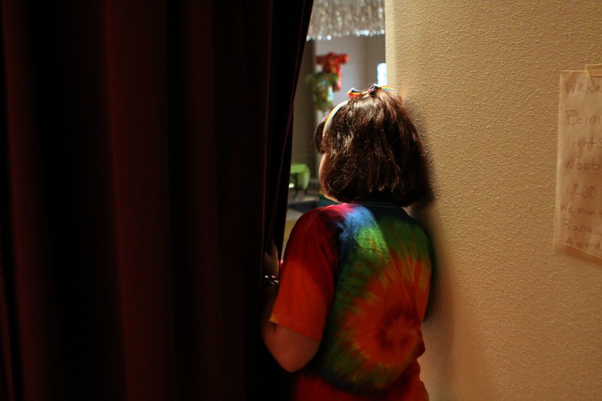 Sophia Mason, 10, looks out from behind the curtain before the beginning of the show.