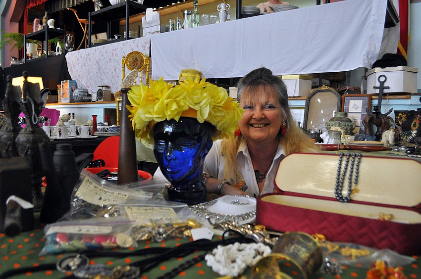 Vendor Lisa Deacon poses with one of her more unique pieces, a glass head used to display hats, often in salons.