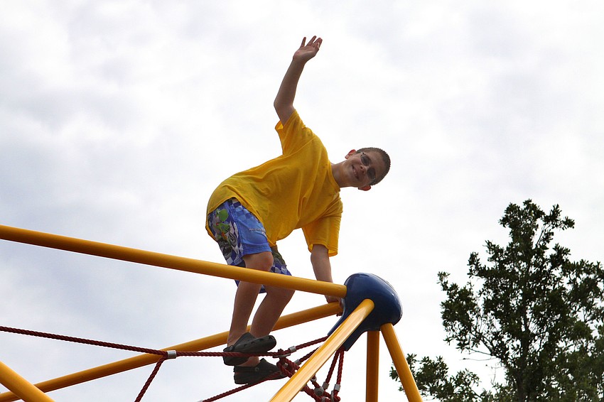 Tyler Helm, 9, waves from the top of the spider web.