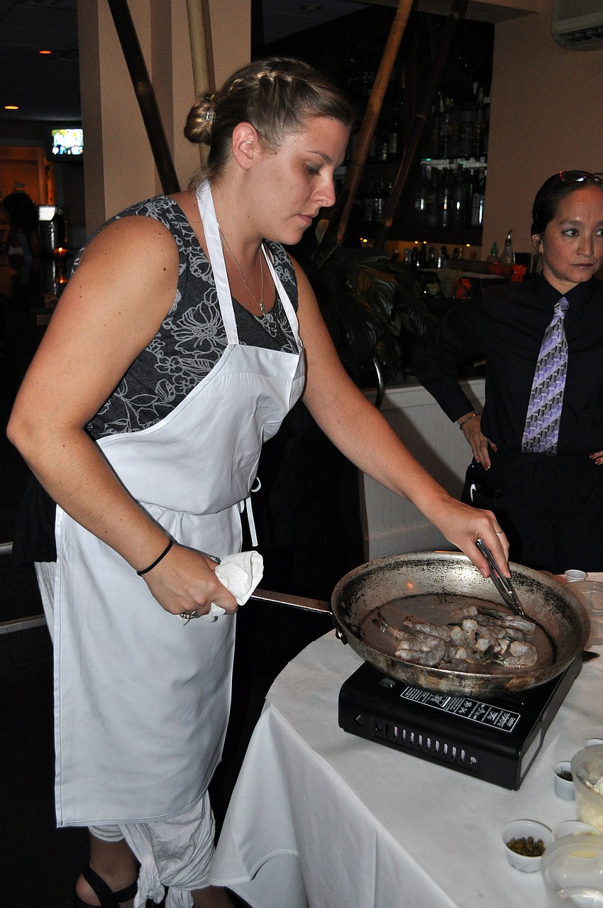 Kristie Ehlers cooks up some shrimp in a hot saucepan, Friday, Aug. 17.