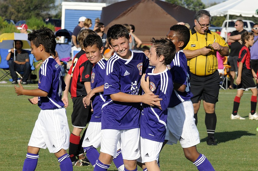 Ten-year-old Ty Hardy, second from right, is congratulated by his Orlando City Soccer teammates after scoring a goal.