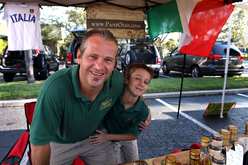 Pino Mazzone with his son, Riccardo, 8, have fun together selling olive oil at the Siesta Key Farmers Market.
