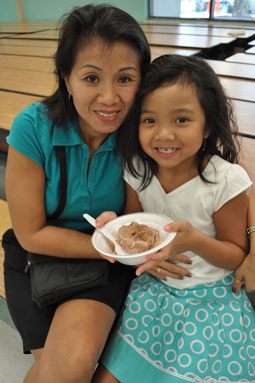 Vee and Skylar Rattana watched children dance as Skylar ate her ice cream.