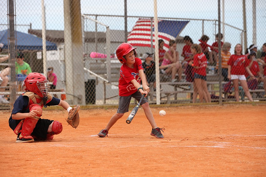 Daniel Yoder goes to hit the ball while Chase Binkley stays in position to catch the pitch.