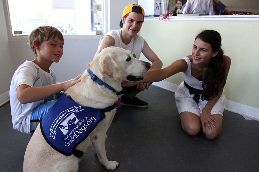 Lynde gets some loving from Nick Schwab, Graham Schwab and Beatriz Urrutia, Saturday, July 21, during Puppy Love at Southeastern Guide Dogs Sarasota.