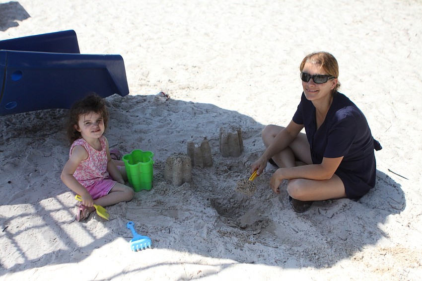 Roisin McMahon, 2, and her mother, Hilary, have fun playing in the sand.
