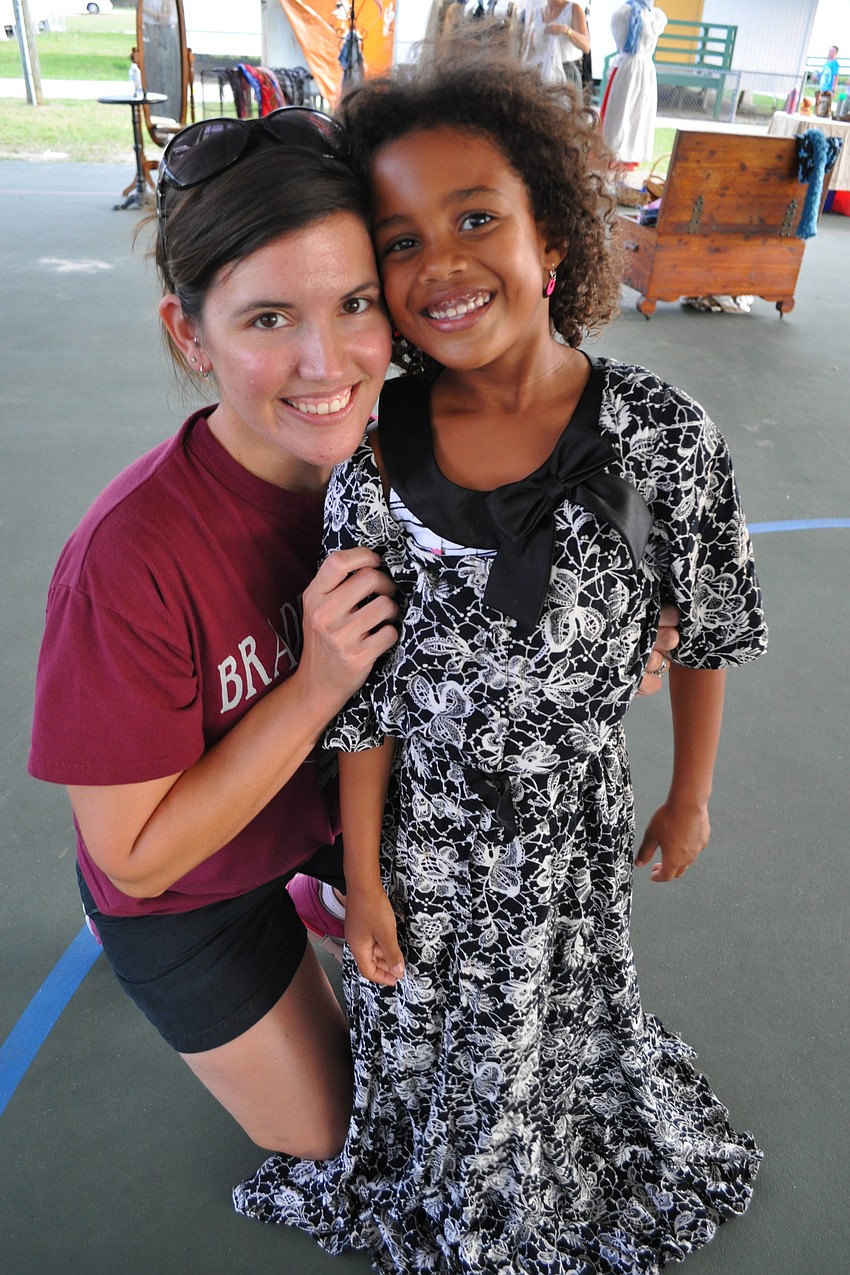 Sara Gaines takes time to twirl with her daughter, Taya, who has fun dressing up in costumes provided at the event.