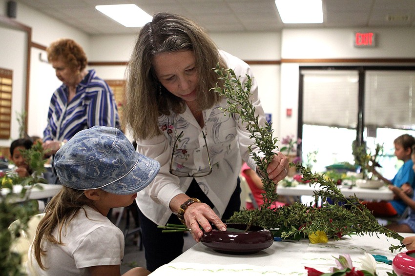 Sensei Gwen Lawry helps Megan Jadush, 10, with her arrangement.