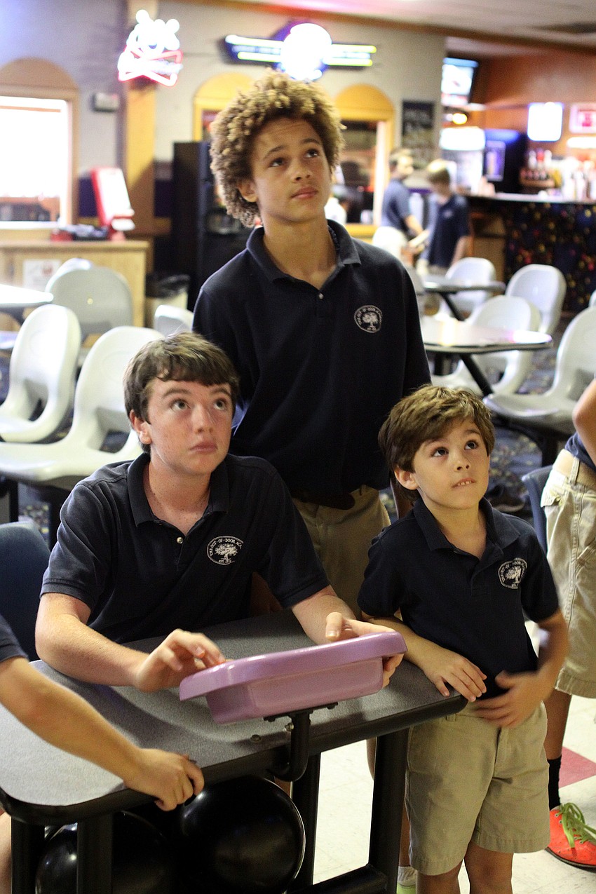 Gus Mahler, 12, Dakota Dickerson, 12, and Drew Hill, 6, look up at the screen as Mahler types in their names, Friday, May 18.