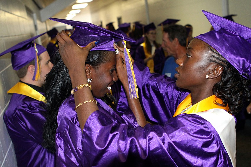 Akira Peterson gets some help putting on her cap from Cherlina Polynice, Saturday, June 2.