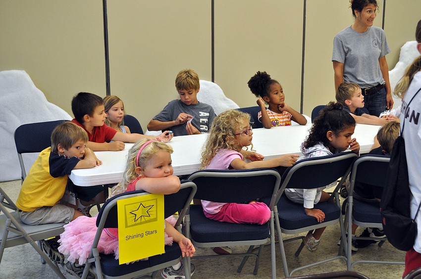 Students watch as a counselor leads the group in prayer.