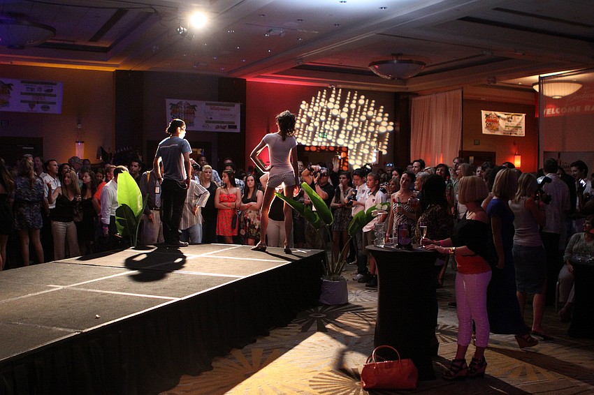 Two models stop and pose at the end of the runway to start of the fashion show portion of the â€œPre-Raceâ€ Party & Fashion Show, Thursday, June 28, at the Hyatt Regency Sarasota.