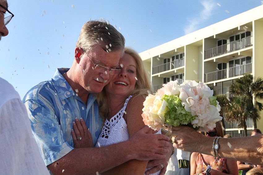 After officially becoming husband and wife, Admiral Steve and Susan Branham duck from the rice throwing and try to get back Susanâ€™s bouquet.