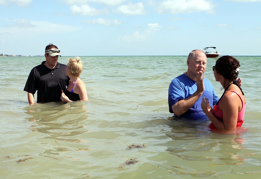 Pastor Craig King talks with Dawn Bazan while Ed Coil, Discipleship Lead Coach, talks with Lisa Glass prior to Bazan and Glassâ€™ baptisms in the Gulf of Mexico, Sunday, July 30, on Siesta Key.