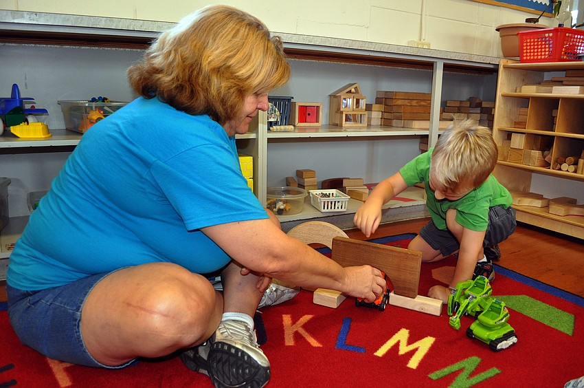 Rosanne Tizzano helps Hayne Falk, 3, build a bridge for the construction trucks to go through, Monday, Aug. 20, at St. Boniface Preschool.