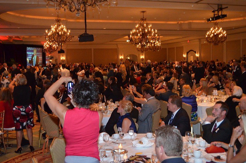 Almost everyone attending the event stood up to photograph Donald Trump.