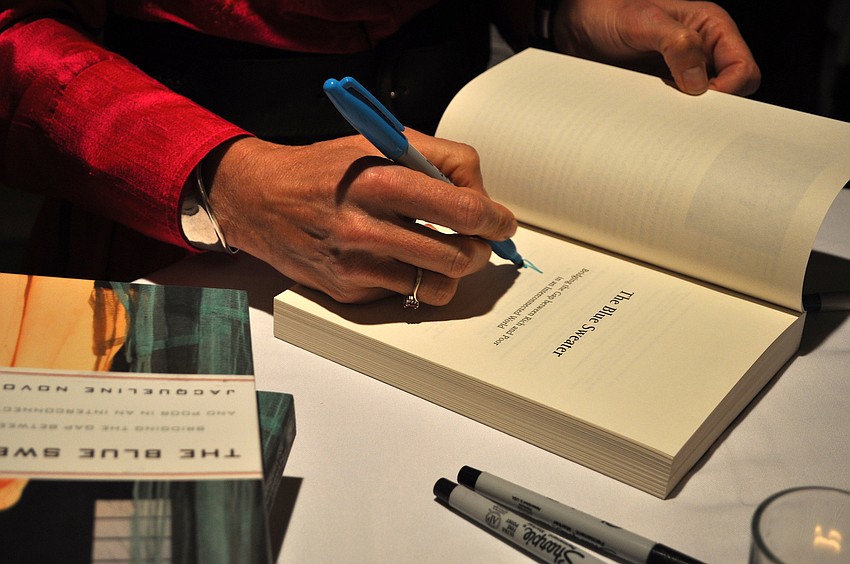 Guest speaker Jacqueline Novogratz signs copies of her book.