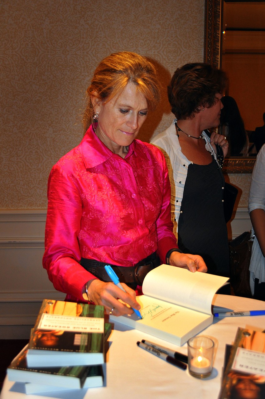 Guest speaker Jacqueline Novogratz signs copies of her book.