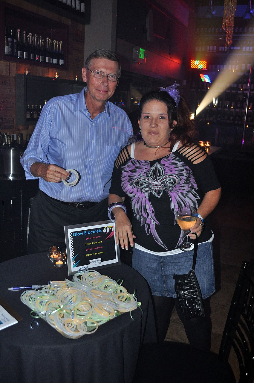 Russ Larsen and Jennifer Bailes-Fretz selling glow bracelets at the Make A Wish Rock of Ages event Friday, Sept. 14.