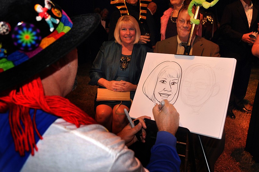 Michael White draws a caricature of Marla and Jim Doss