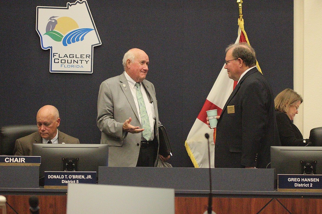 County Commissioner David Sullivan speaks to commissioner Greg Hansen. Commission Chairman Donald O'Brien is at left. Photo by Jonathan Simmons