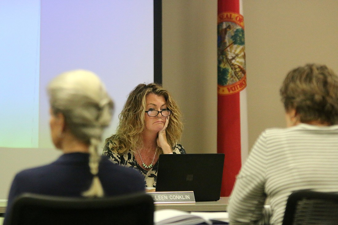 School Board member Colleen Conklin, center, examines data as board attorney Kristy Gavin and planning coordinator Patty Bott summarize the district's impact fee presentation. Photo by Brent Woronoff