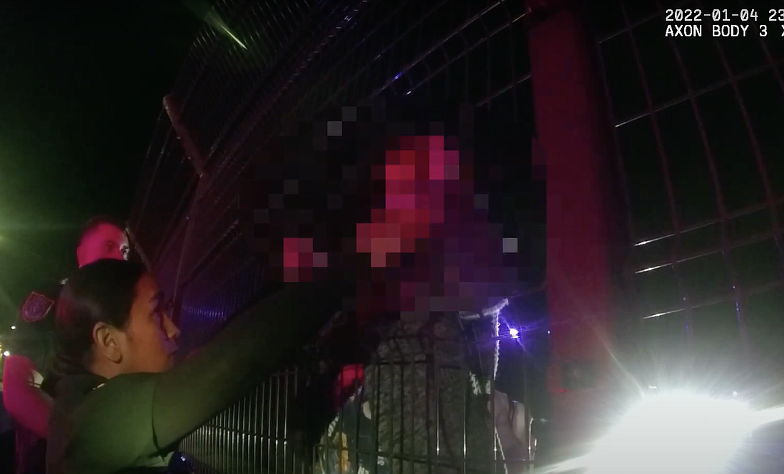 A deputy holds the teen's hands as deputies work to coax her off the bridge. Image from FCSO body camera footage