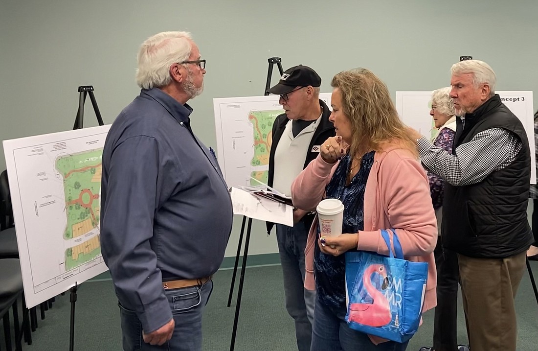 Residents examine the four concept boards at the public meeting for the renovation of Cassen Park. Photo by Jarleene Almenas