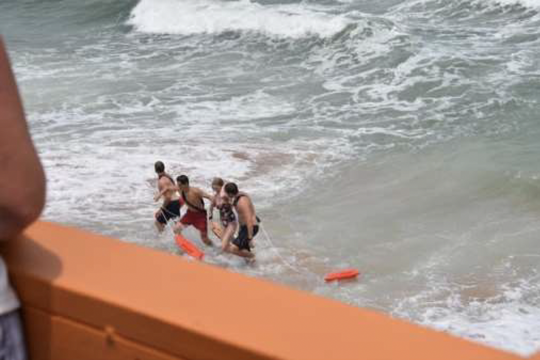 Lifeguards rescue a woman who was caught in a rip current. Photo courtesy of the city of Flagler Beach