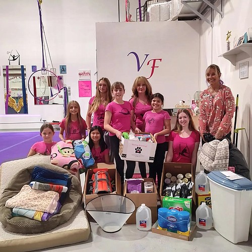 VertiFit Aerial Arts owner Barrie Michaels and students donate items to the Flagler Humane Society's Executive Director Amy Wade Carotenuto. Courtesy photo
