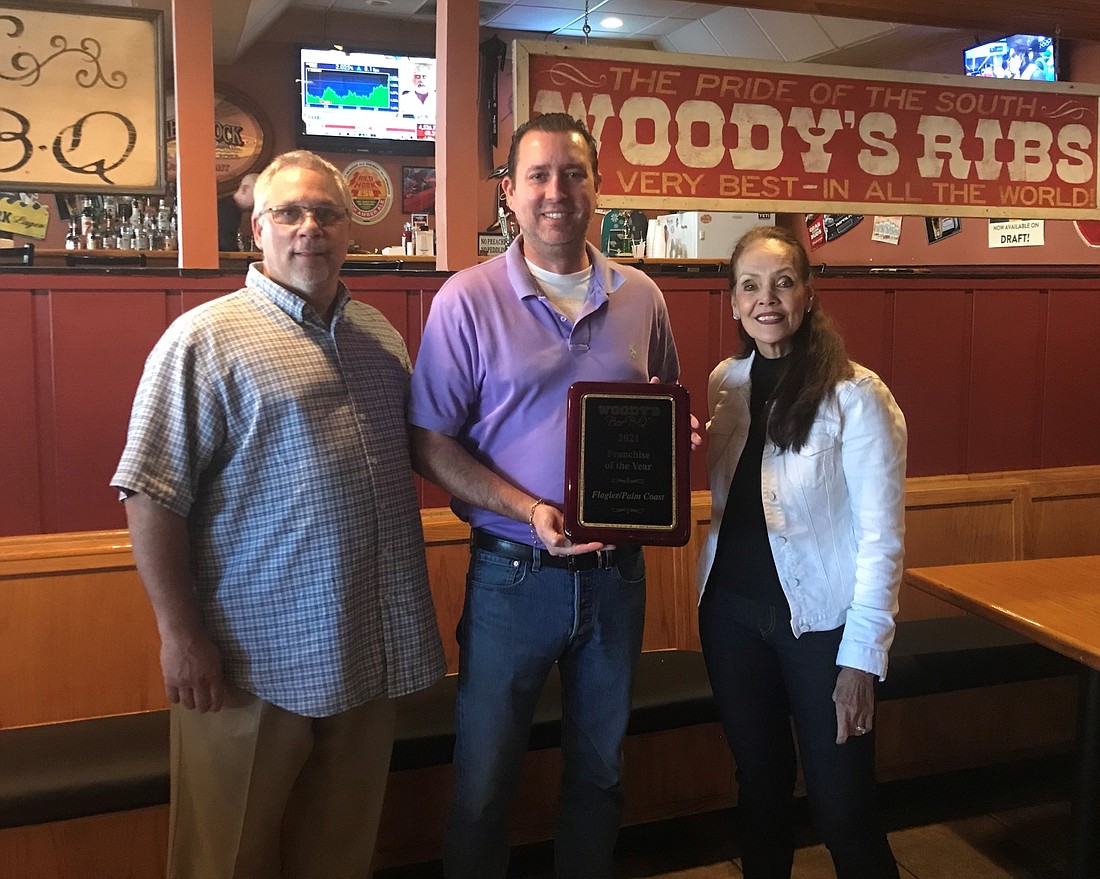 Woody's VP of Operations Jay Vail, Owner of Woody's Bar-B-Q of Flagler Beach and Franchisee of the Year Matt Crews and President/COO Yolanda Mills-Mawman. Courtesy photo