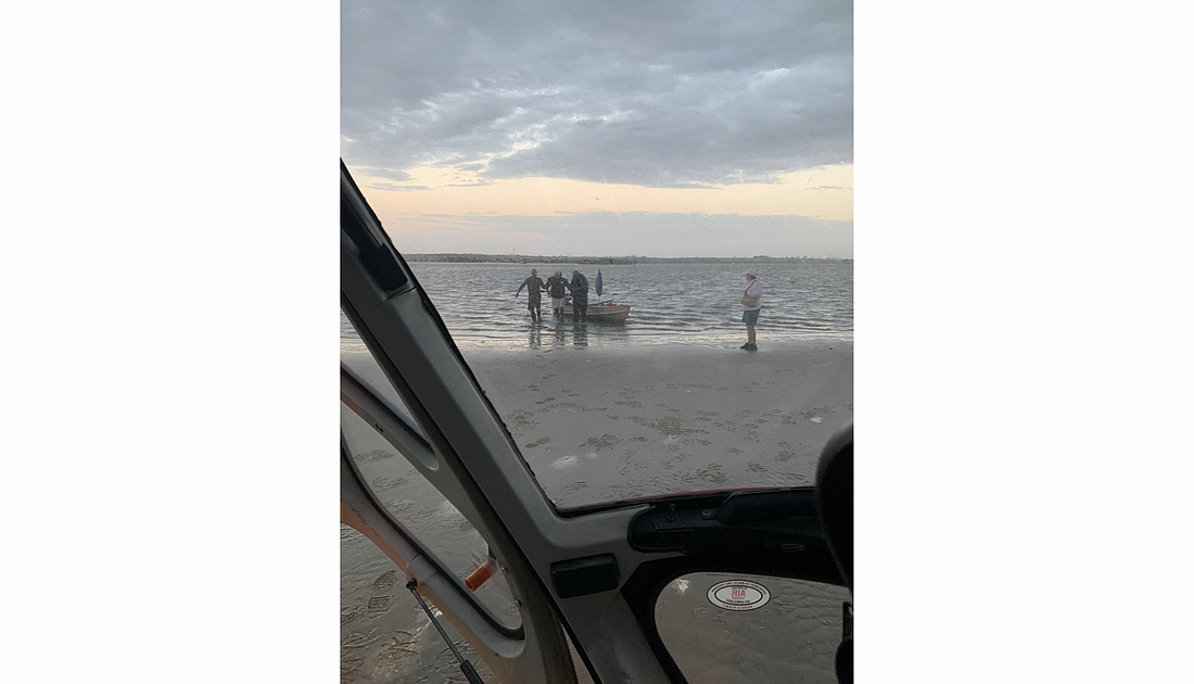 Rescuers assist the boaters. Photo courtesy of the Flagler County government