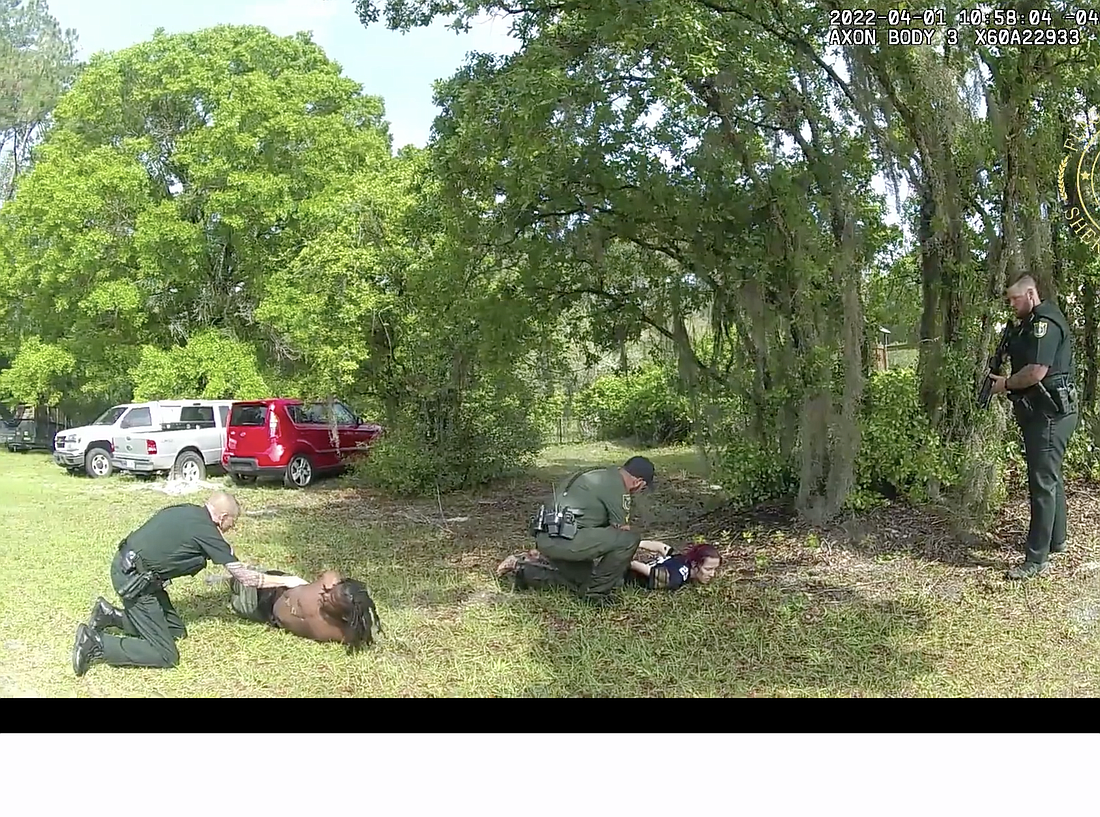 Deputies arrest suspects Randy Moore and Brooke Moore in this image from a deputy's body camera footage.