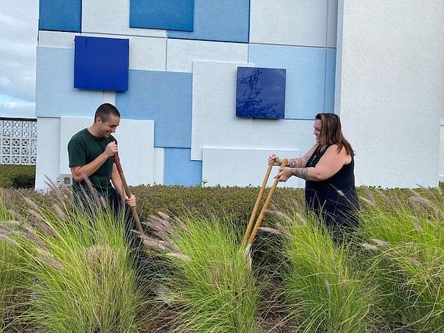Tanger Outlets Daytona Beach Office Manager Gino Girola and Operations Director Stevie Carbonell plant a tree at the center. Courtesy photo