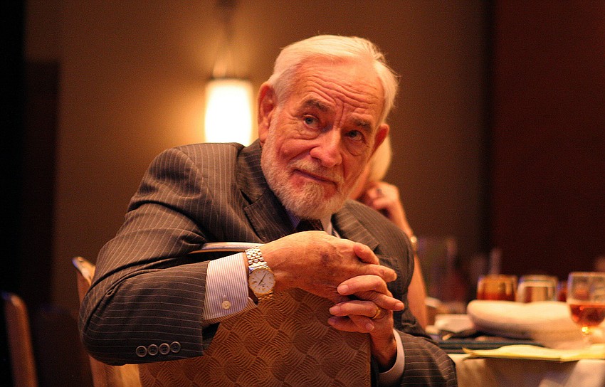 Gil Waters listens to people on stage talk about his achievements.