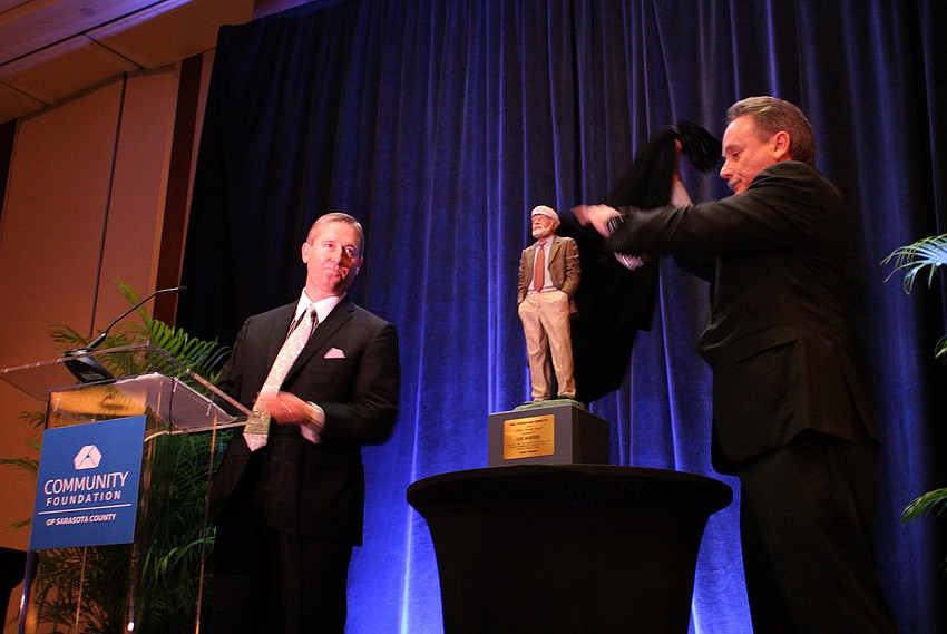 Craig Johnson stands back as Chris Waters unveiled the Lifetime Visionary Award of Gil Waters.