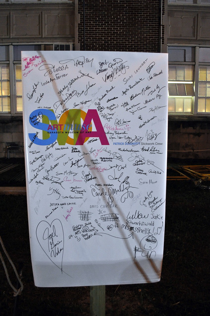 People signed their names on a sign by the stick sculpture out in front of the Historic Sarasota High School.