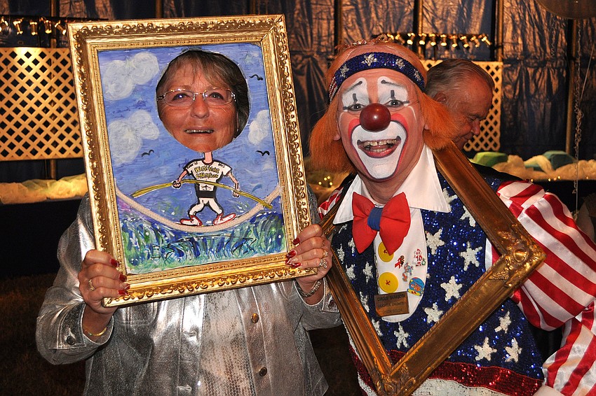 Lindy Smith poses within a picture frame with Chuck Sidlow after she and Jack McKissock won the live auction to go with Nik Wallenda to the Grand Canyon in June. The final price was $16,000.