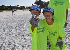 Dylan Colby, 8, and his brother Clay, 10, found a chunk of metal during the 2012 International Coastal Cleanup on Siesta Key beach, which began at 8 a.m. today.