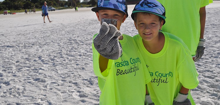 Dylan Colby, 8, and his brother Clay, 10, found a chunk of metal during the 2012 International Coastal Cleanup on Siesta Key beach, which began at 8 a.m. today.