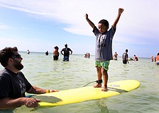 Mark Weeks laughs as Caiden Woodworth, 5, raises his arms up in the air victoriously Saturday, Sept. 15 during Hang 10 for Autism at Siesta Key Public Beach.