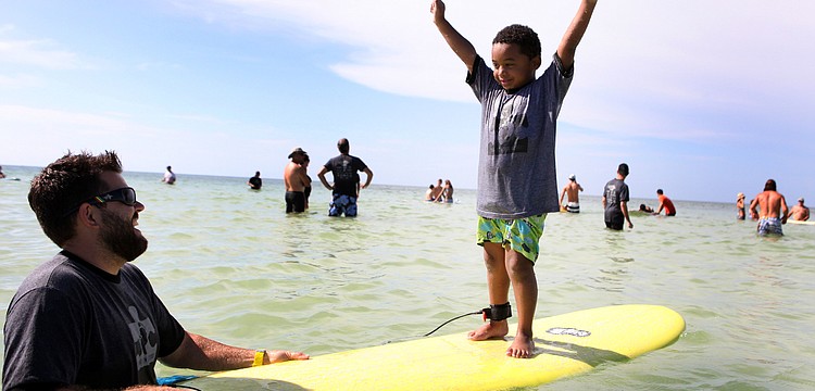 Mark Weeks laughs as Caiden Woodworth, 5, raises his arms up in the air victoriously Saturday, Sept. 15 during Hang 10 for Autism at Siesta Key Public Beach.
